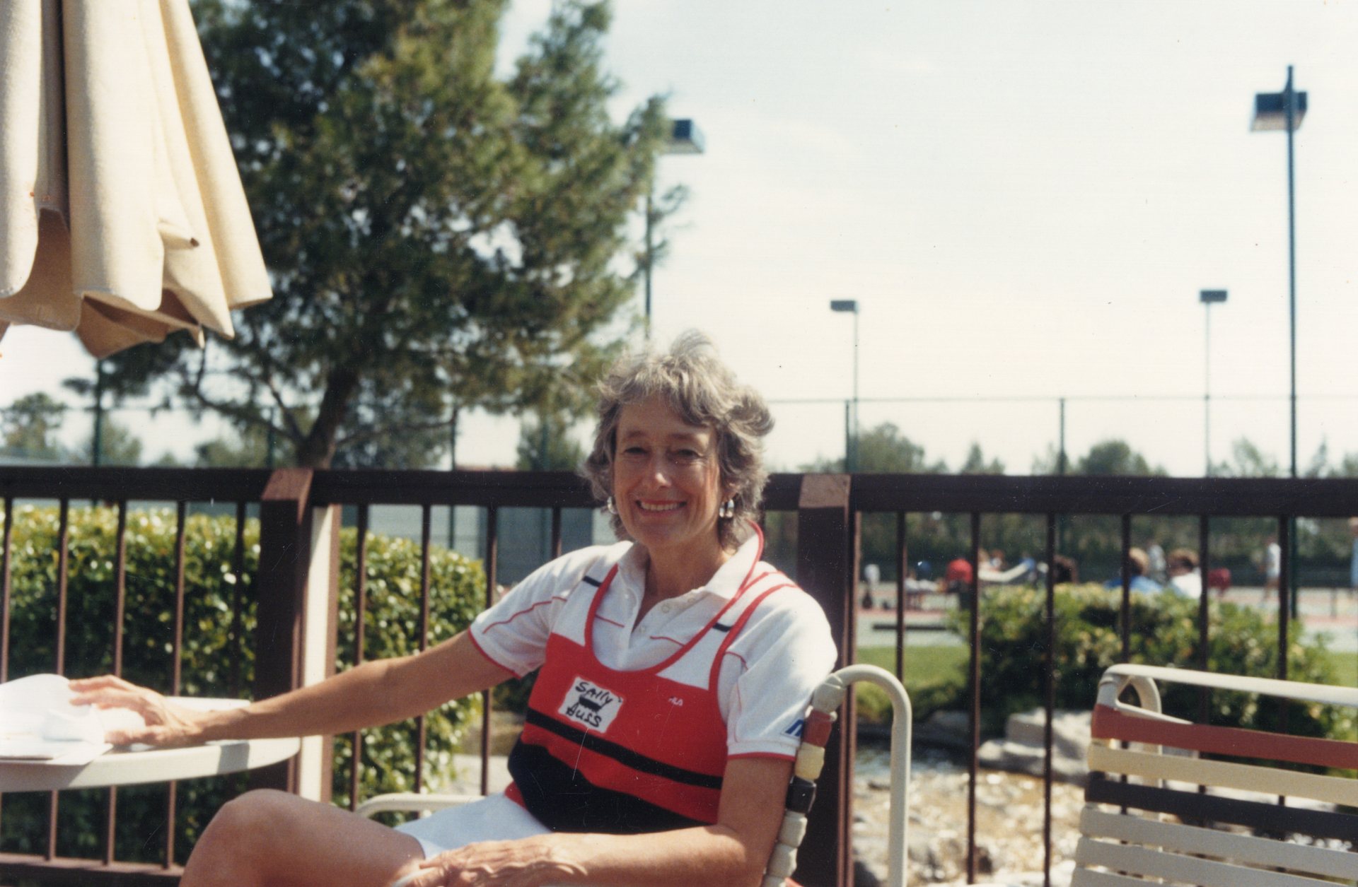 Sally Huss smiling at her tennis club in the 1980s