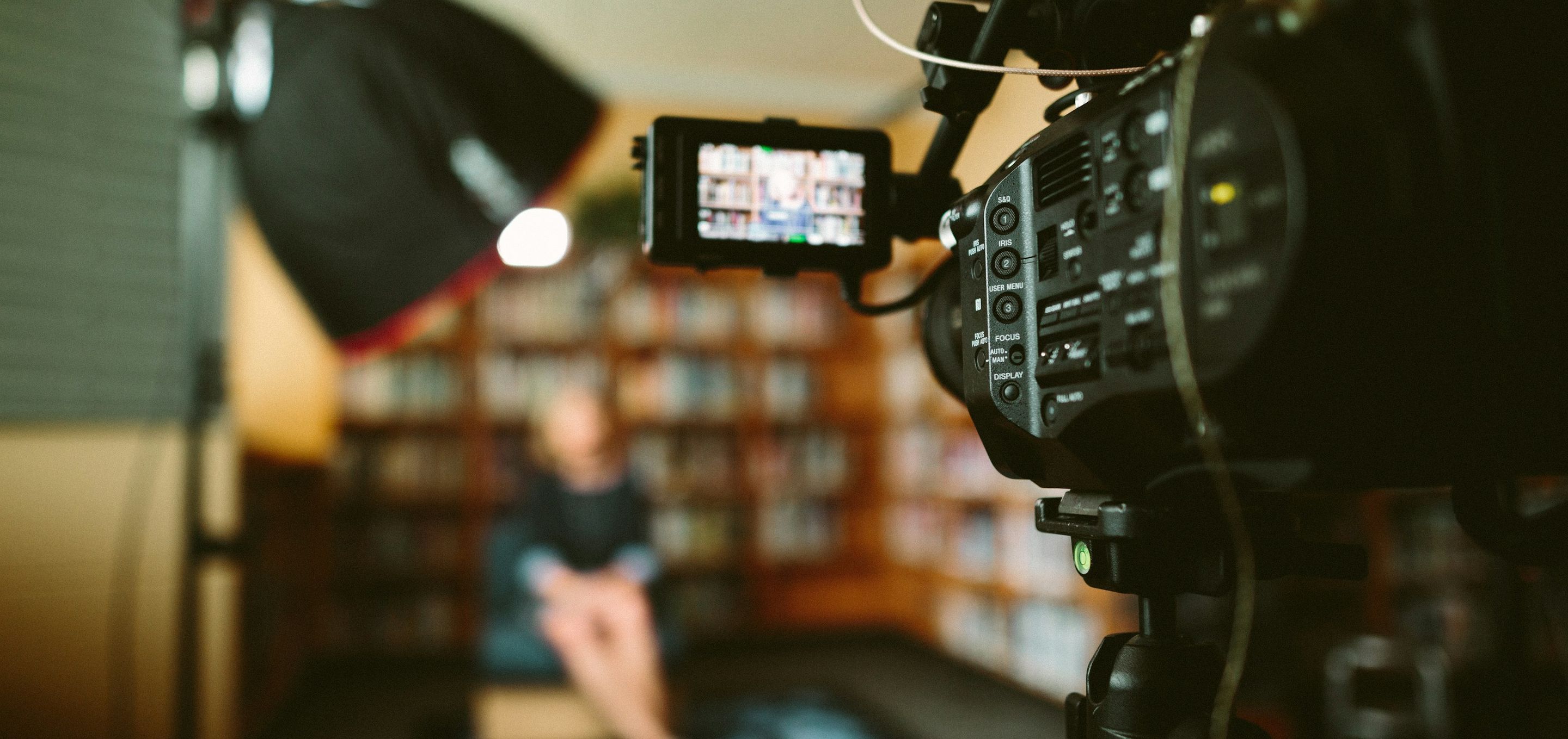 A cinema camera filming an interview in a library